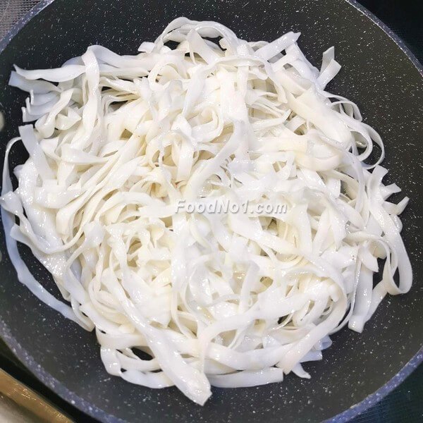 加入寬河粉,翻炒均勻,加入生抽、老抽、蠔油、糖、鹽調味,翻炒至河粉上色。